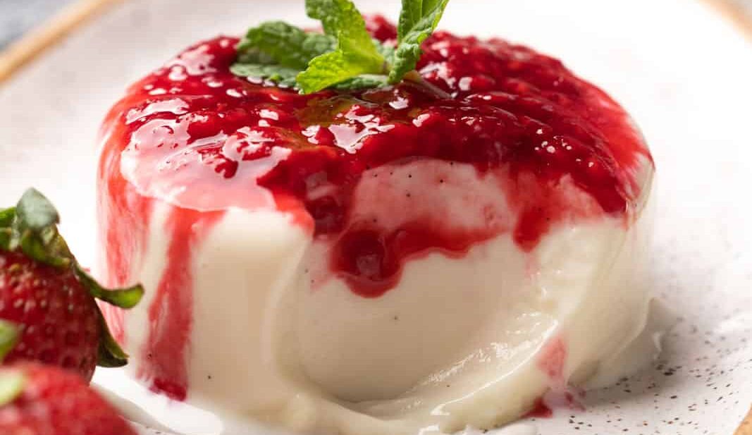 Picture of panna cotta on a plate with a bite taken out of it