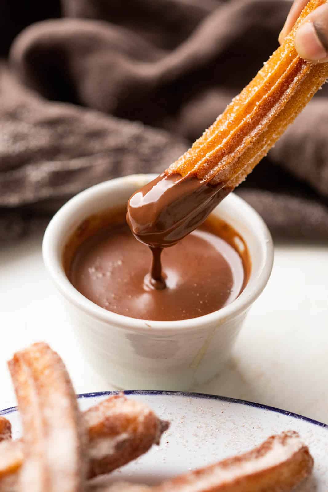 Dipping a churro in chocolate sauce