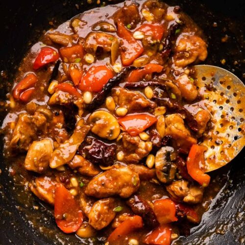 Kung Pao chicken pictures in the wok that it was cooked in with a skimmer