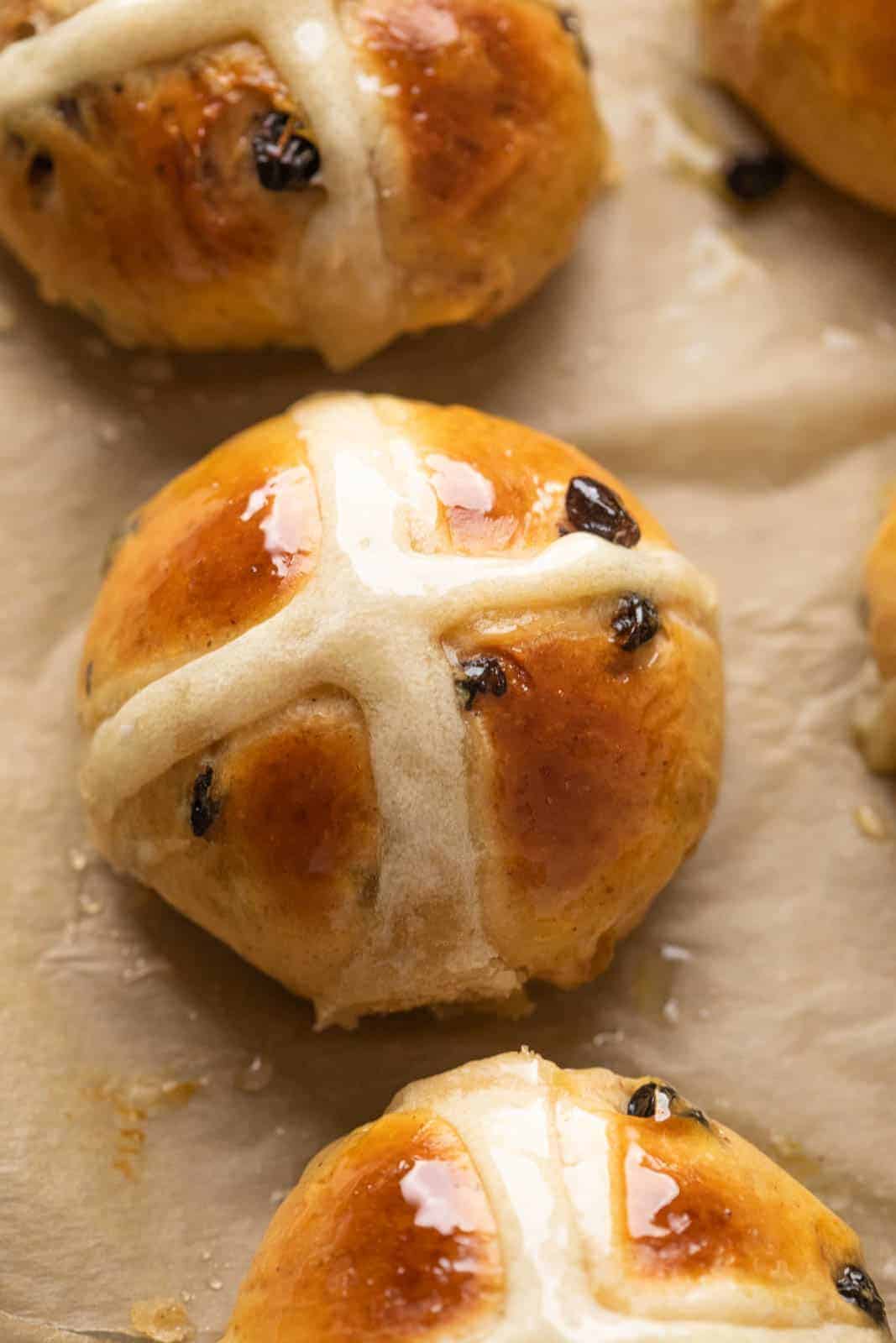Closeup of one hot cross bun to show how beautifully glazed they are