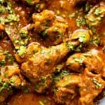 Close up of chicken curry to show texture of the gravy and succulent, juicy pieces of chicken