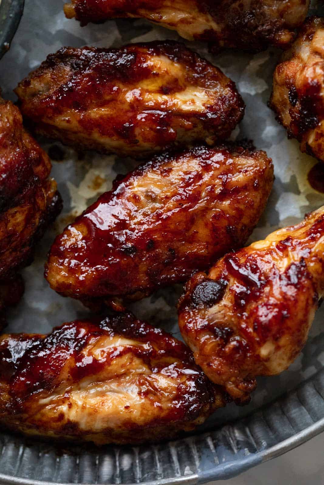 Closeup of a few chicken wings to show their charred sauciness