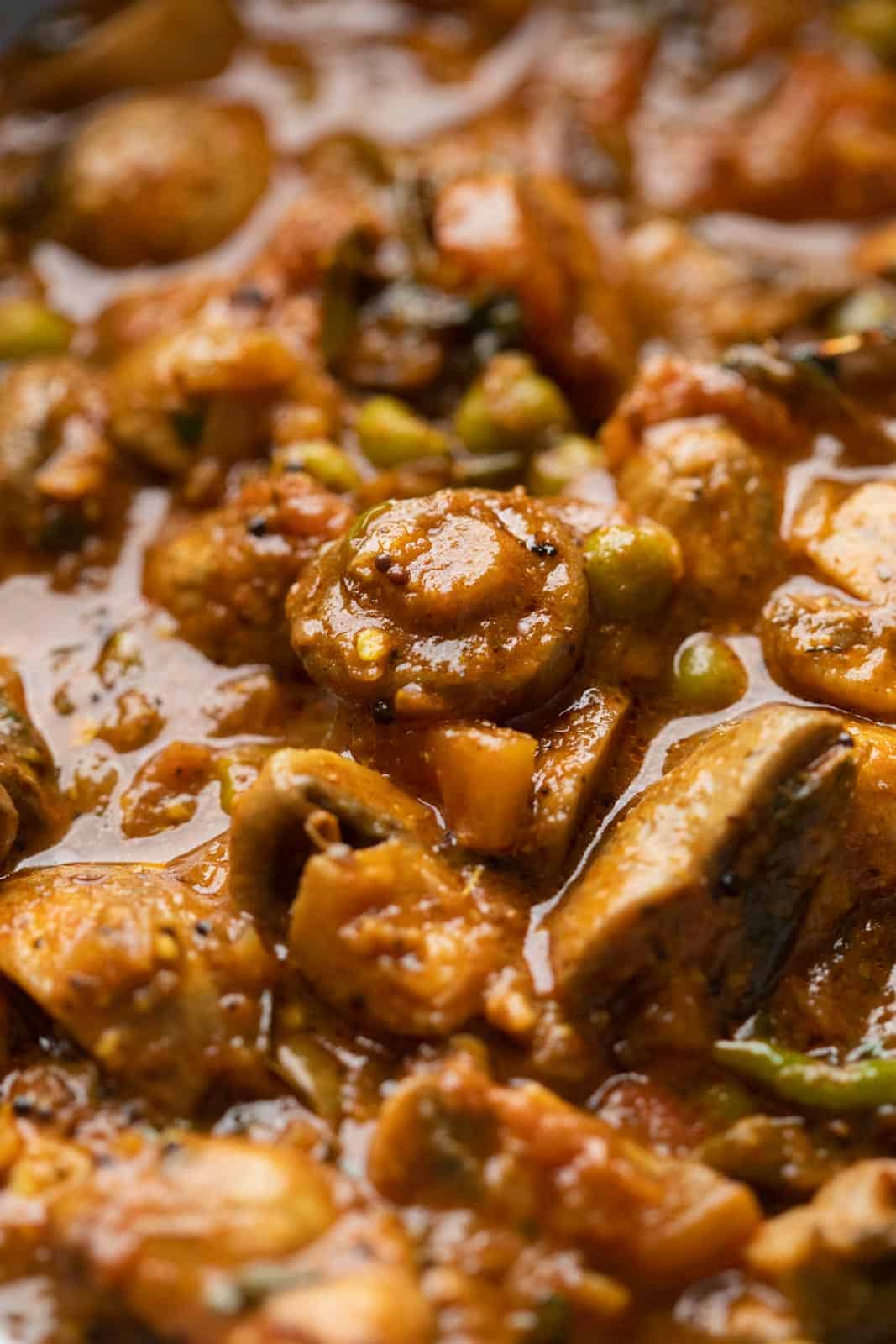 Close up picture of mushroom masala to show the texture of the gravy and the mushrooms