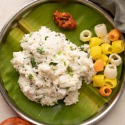 Curd rice served on a plate with pickle and fryums