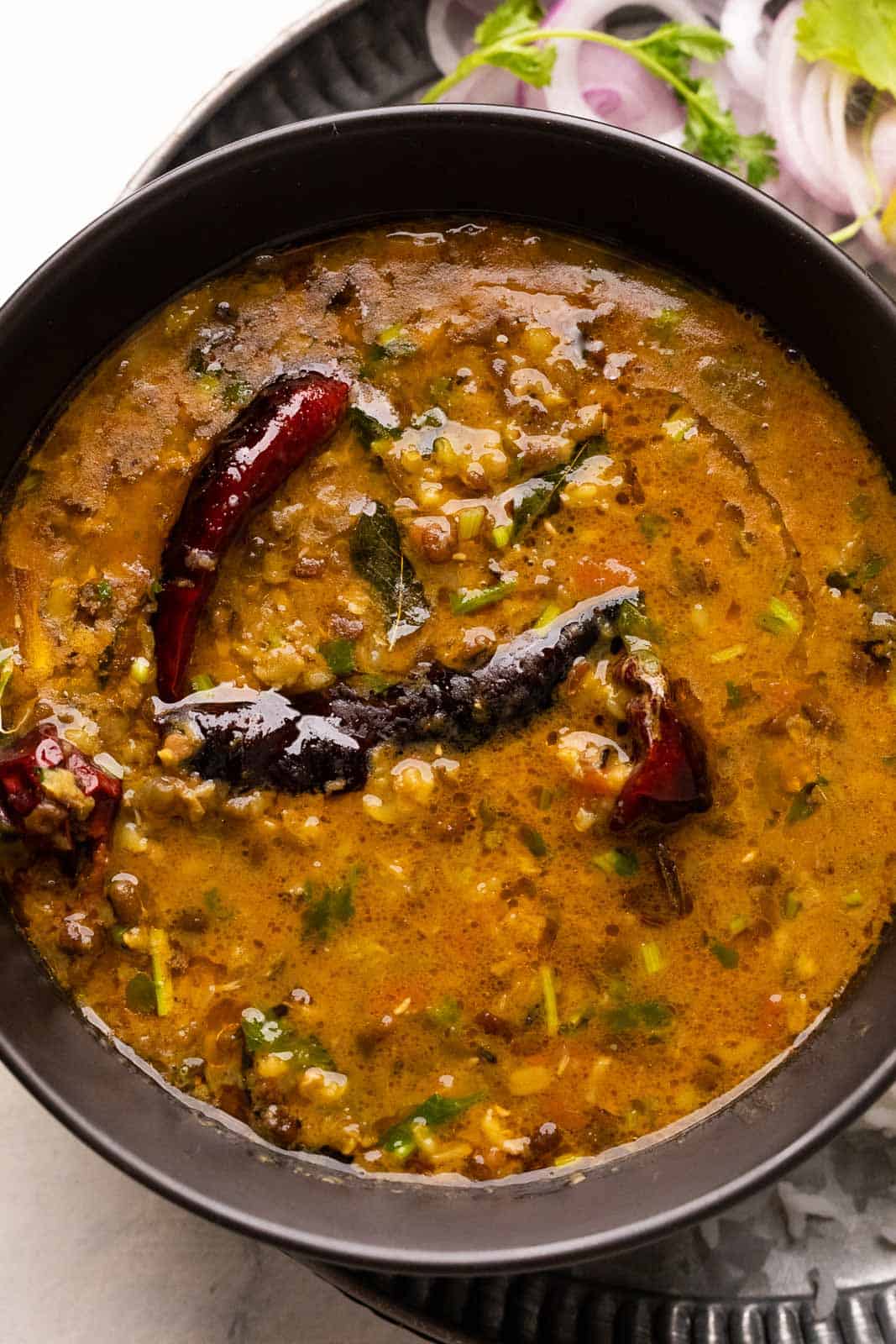 Closeup of a bowl of dhaba style moong dal with tadka on top