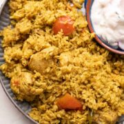Chicken Pulao served on a grey plate with raita