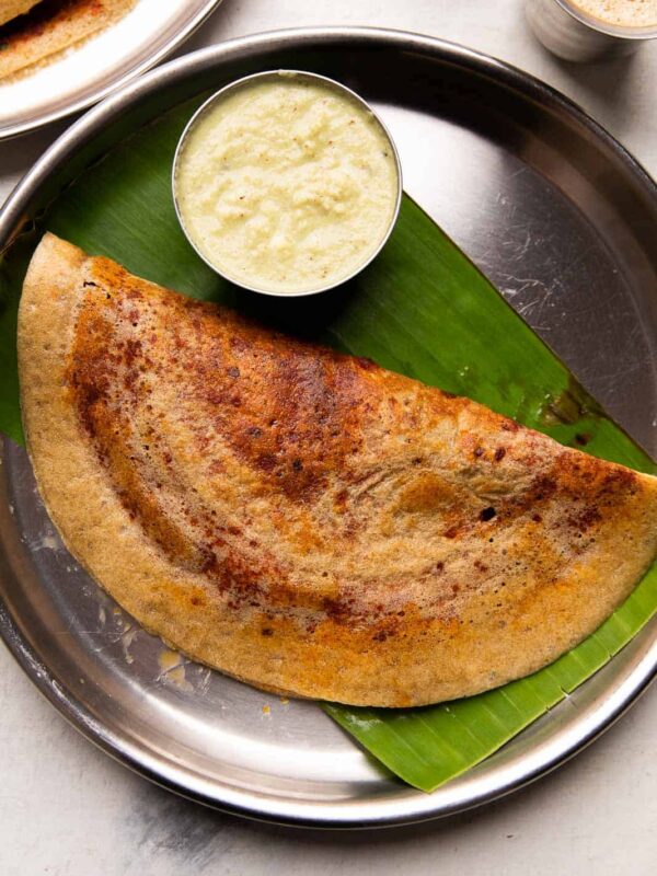 Millet mysore masala dosa served on a steel plate with chutney and filter coffee
