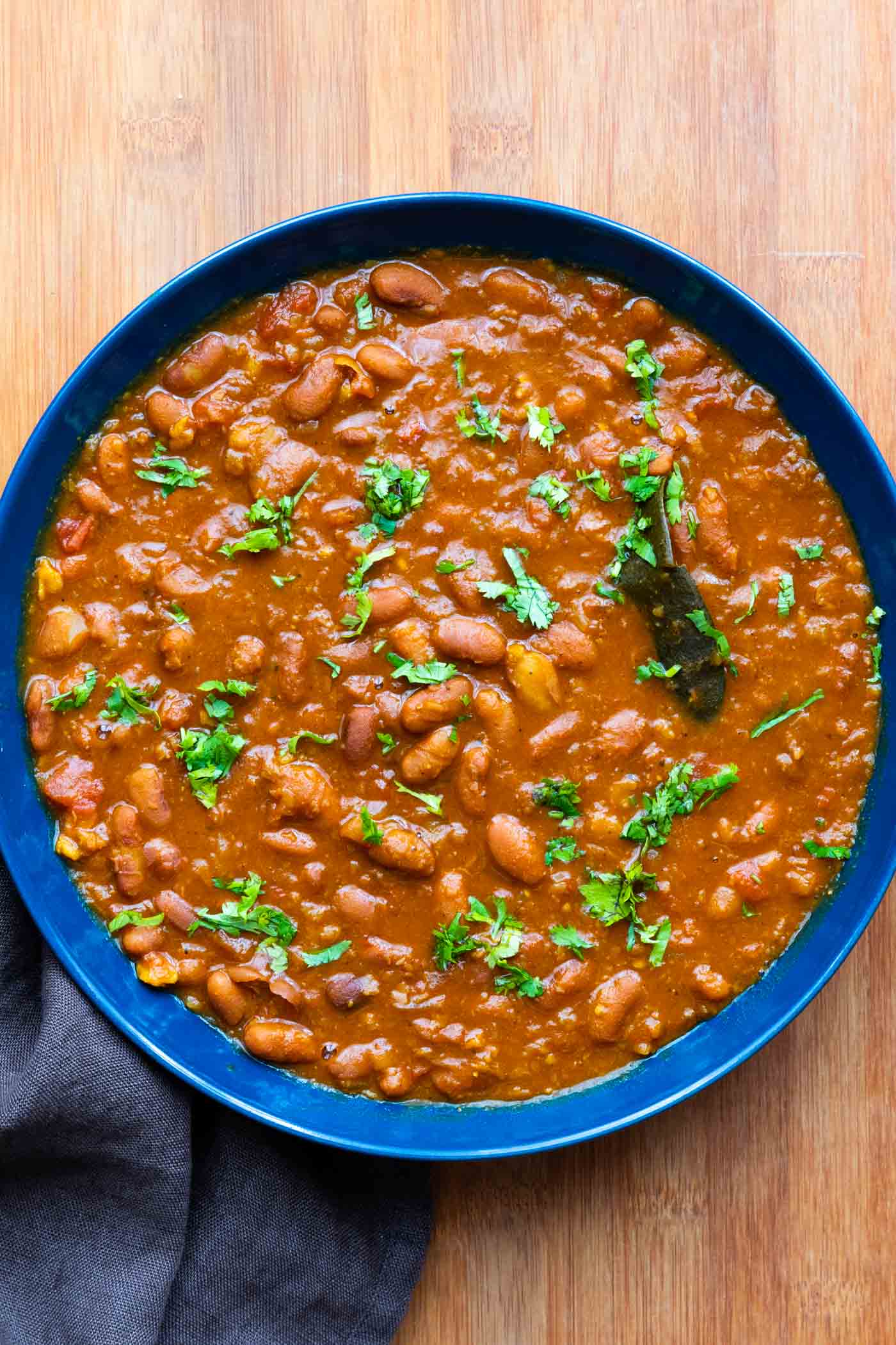 Rajma Masala served in a blue bowl with chopped coriander sprinkled over