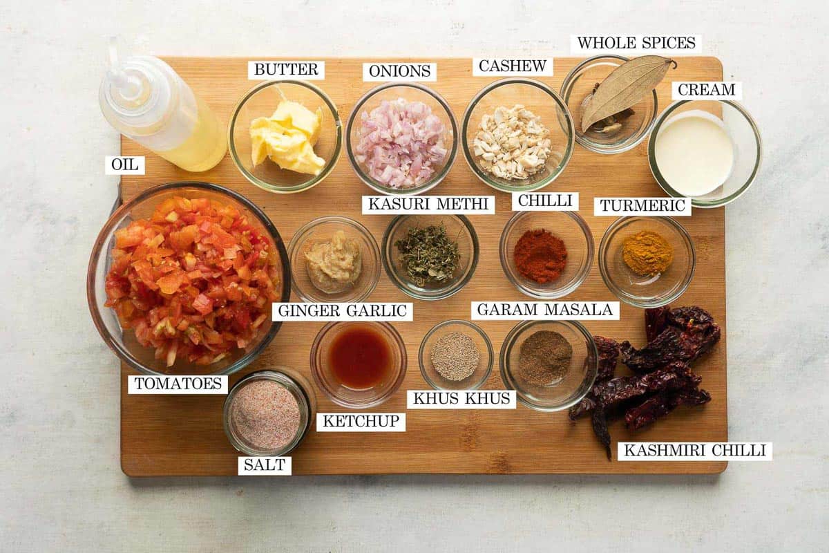 Ingredients for paneer butter masala laid out and labeled on a brown board