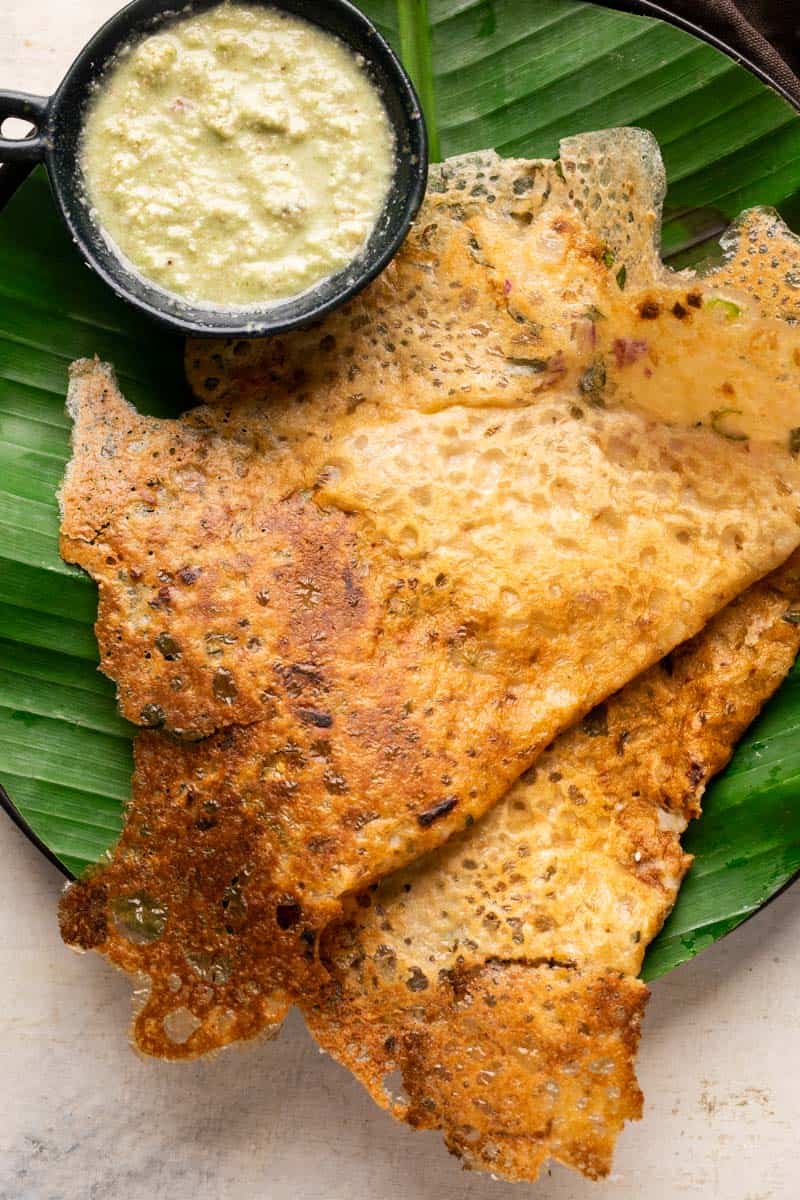Instant oats dosas served on a banana leaf lined plates with coconut chutney