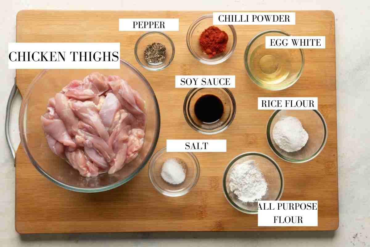 Ingredients for marinating and deep frying dragon chicken laid out with text to identify them