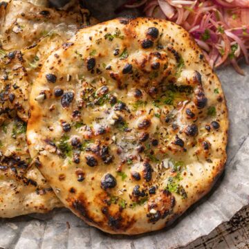 Closeup of kulcha brushed with butter on a plate