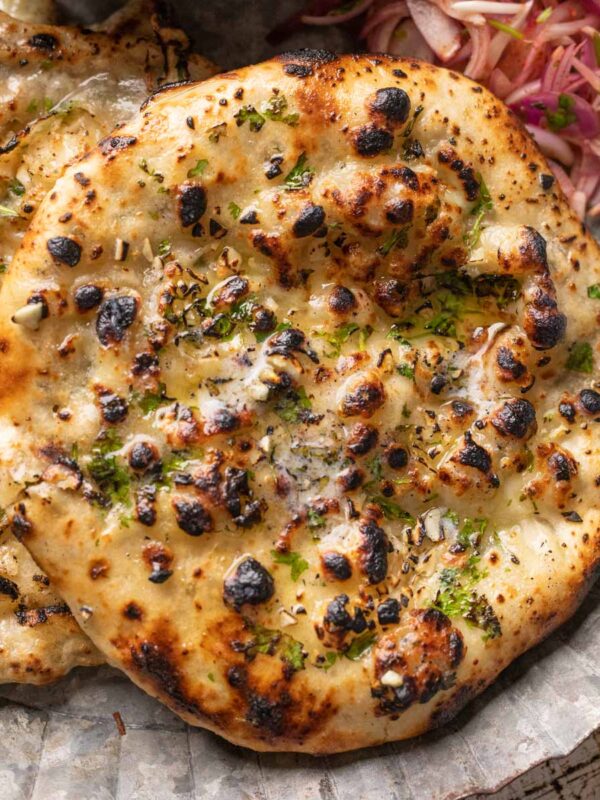 Closeup of kulcha brushed with butter on a plate