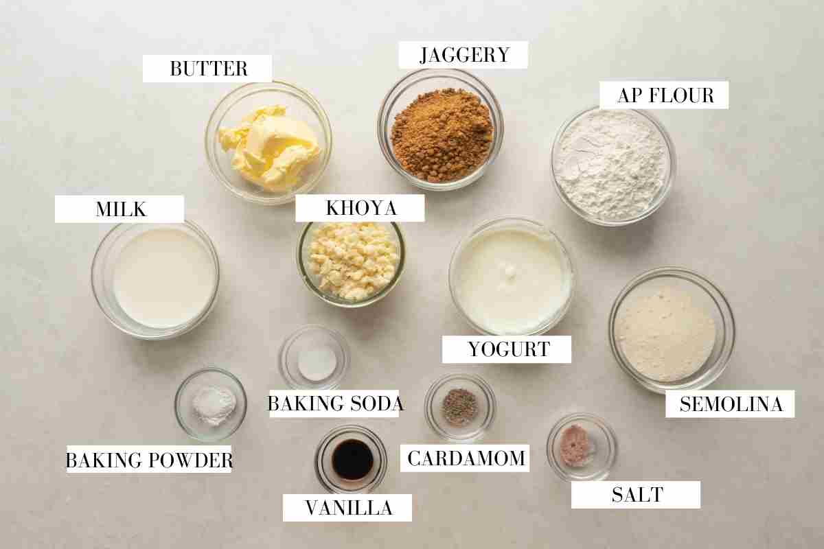 Ingredients for mawa cake laid out on a white table with text to identify them