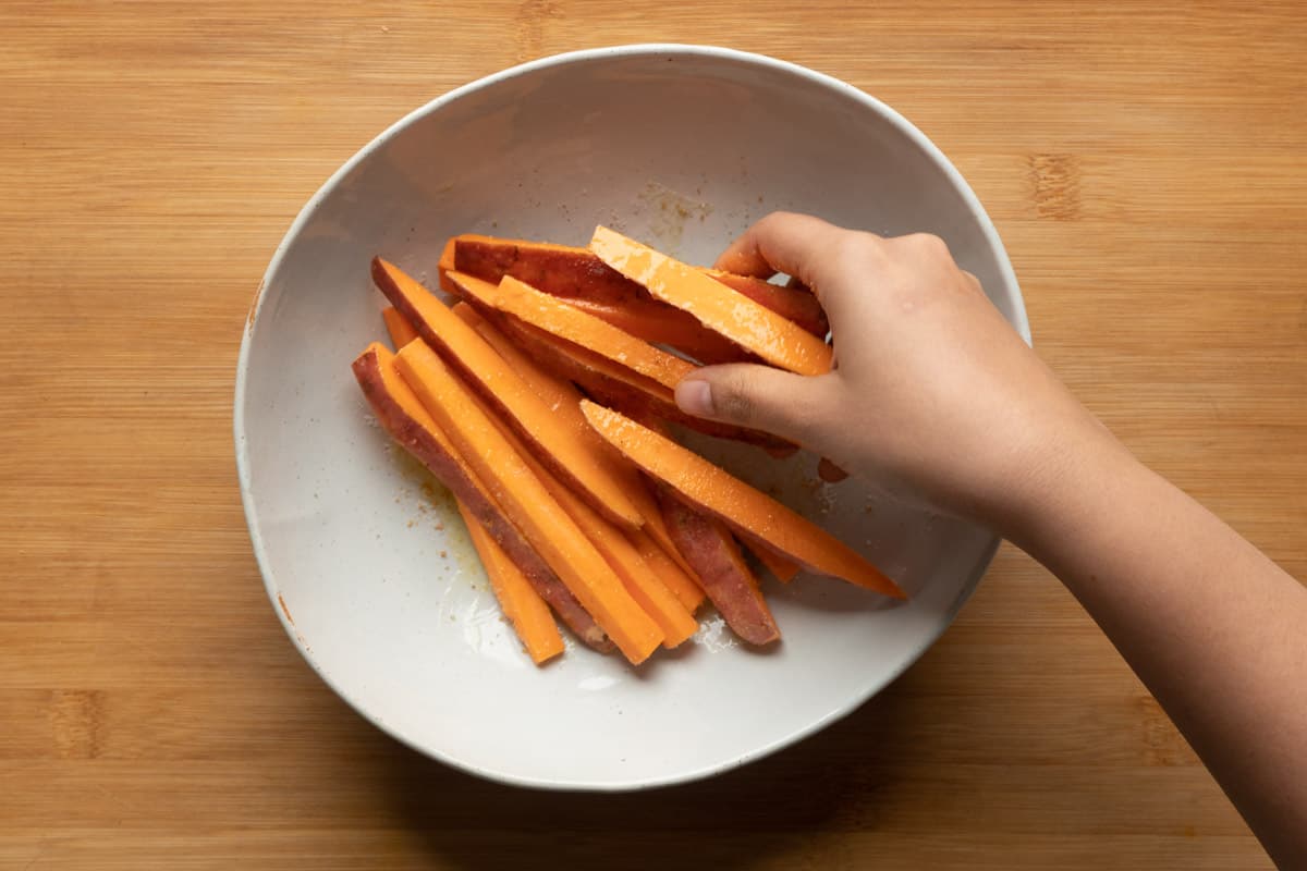 Picture of tossing sweet potato fries in seasoning