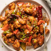 Szechuan Chicken served on a white plate with a fork
