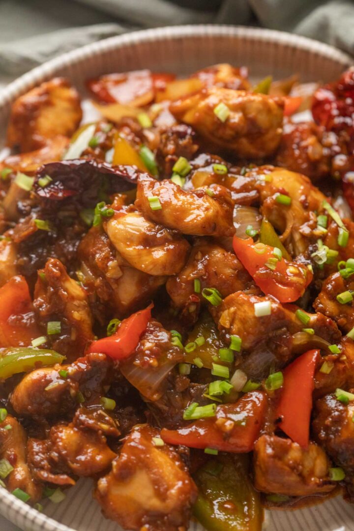 Close up of szechuan chicken served on a white plate