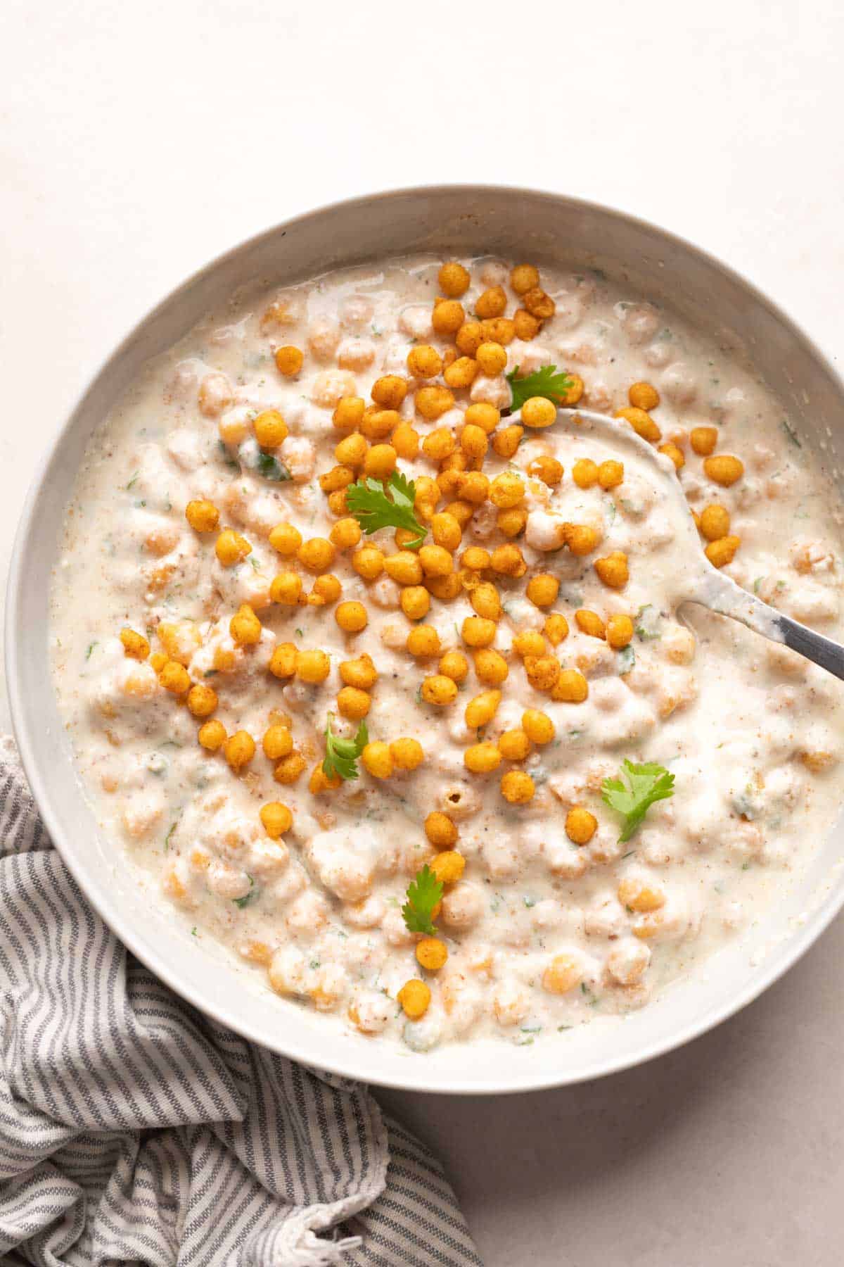 Boondi Raita served in a white bowl with coriander on top