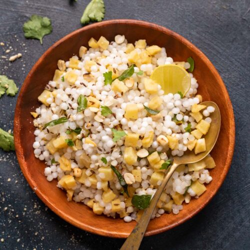 Sabudana khichdi served in a brown bowl with a spoon
