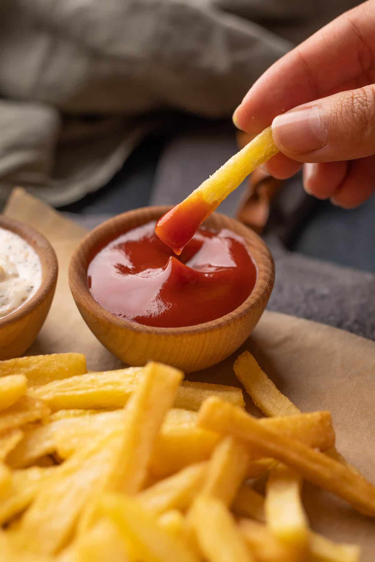 Close up of french fry dipped in ketchup