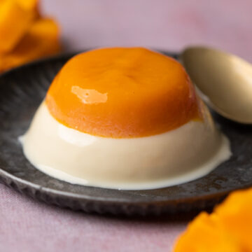 Mango Panna Cotta served on a grey plate with a spoon