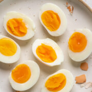 Different varieties of hard boiled eggs placed on a white plate