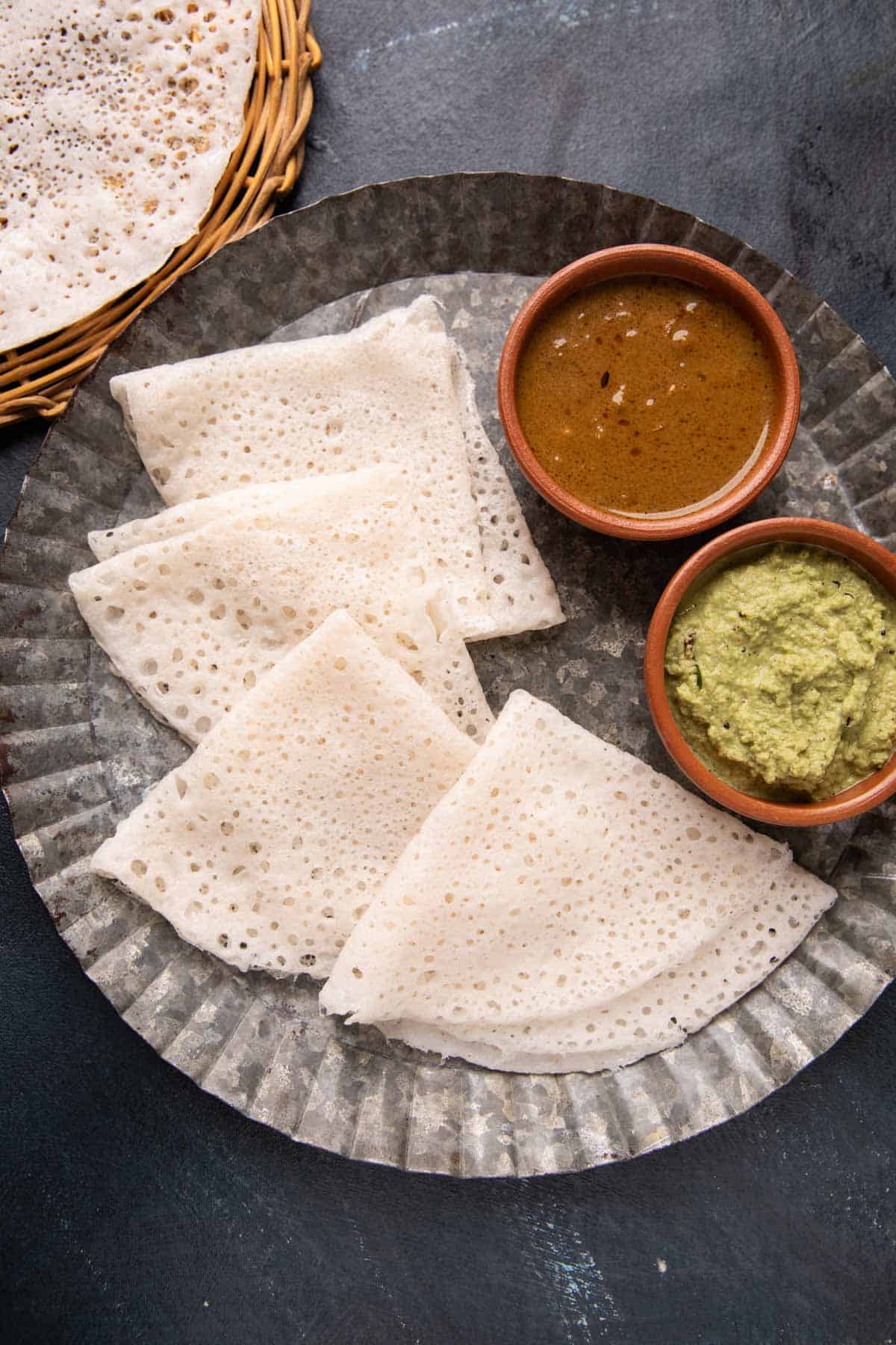 Neer Dosas served on a plate with chutney and curry