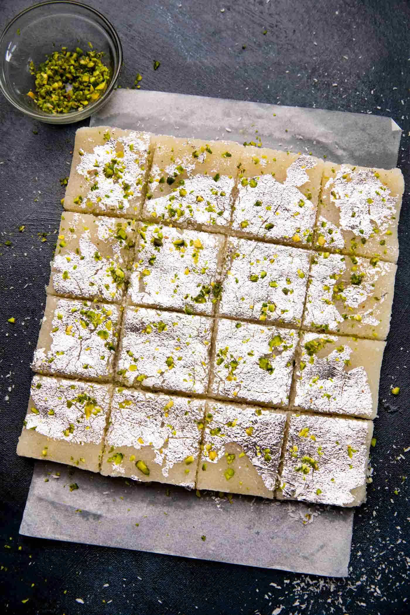 Coconut Barfi sliced and laid out on parchment paper