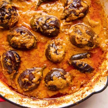 Picture of stuffed brinjal curry in a red enamel pan