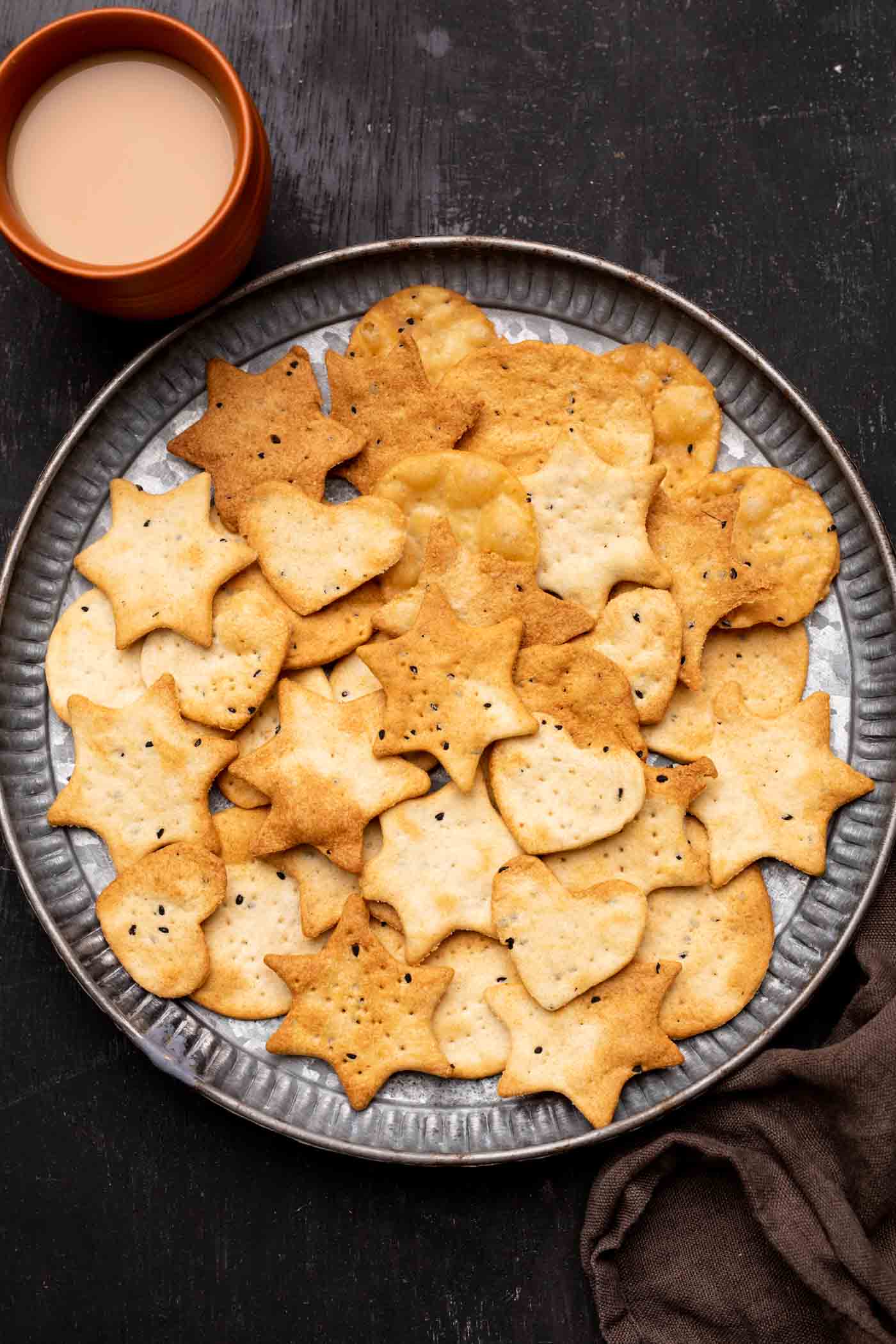 Air Fryer papdi served on a plate with chai on the side