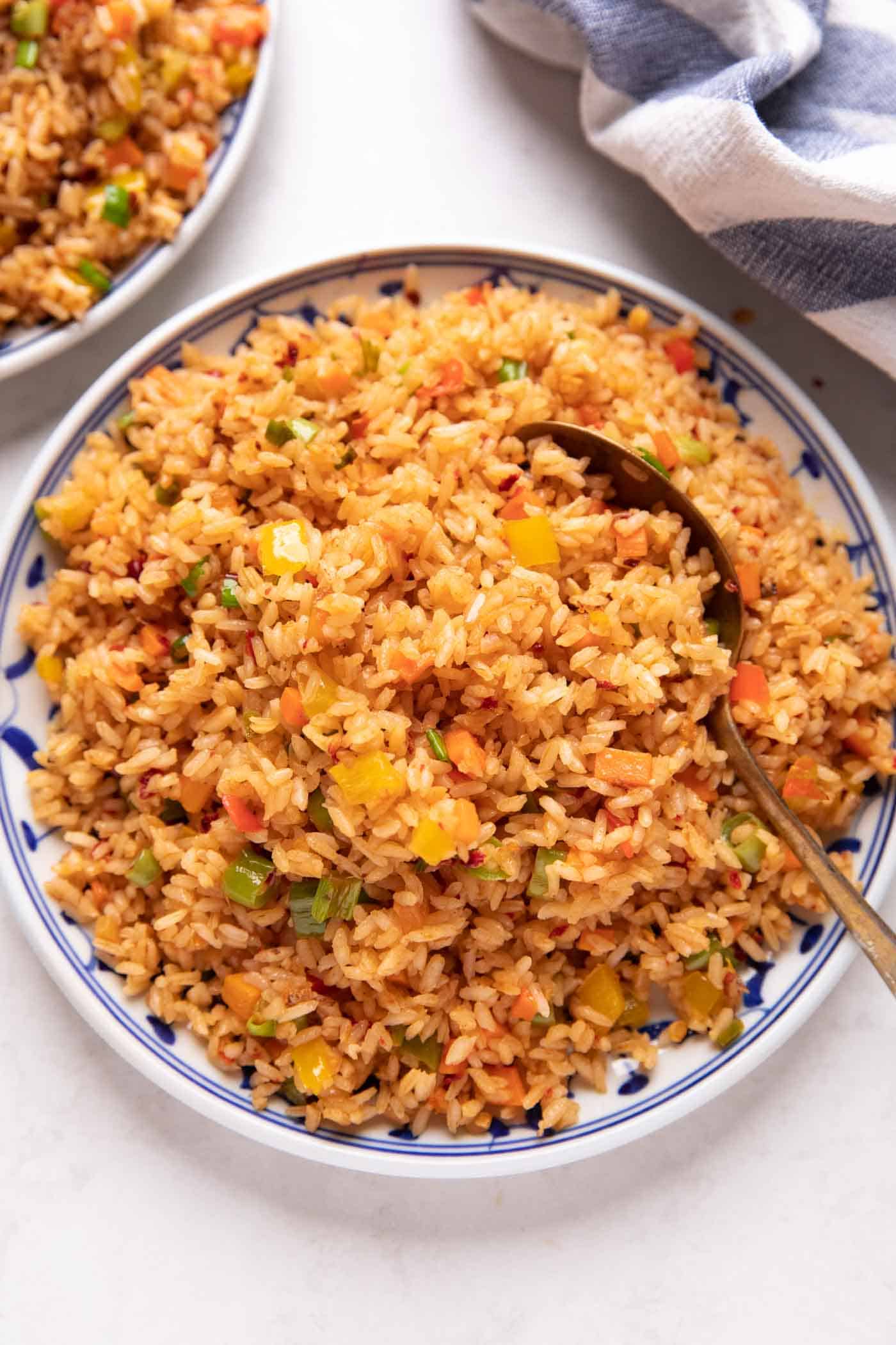 Picture of chilli garlic fried rice served on a white and blue plate