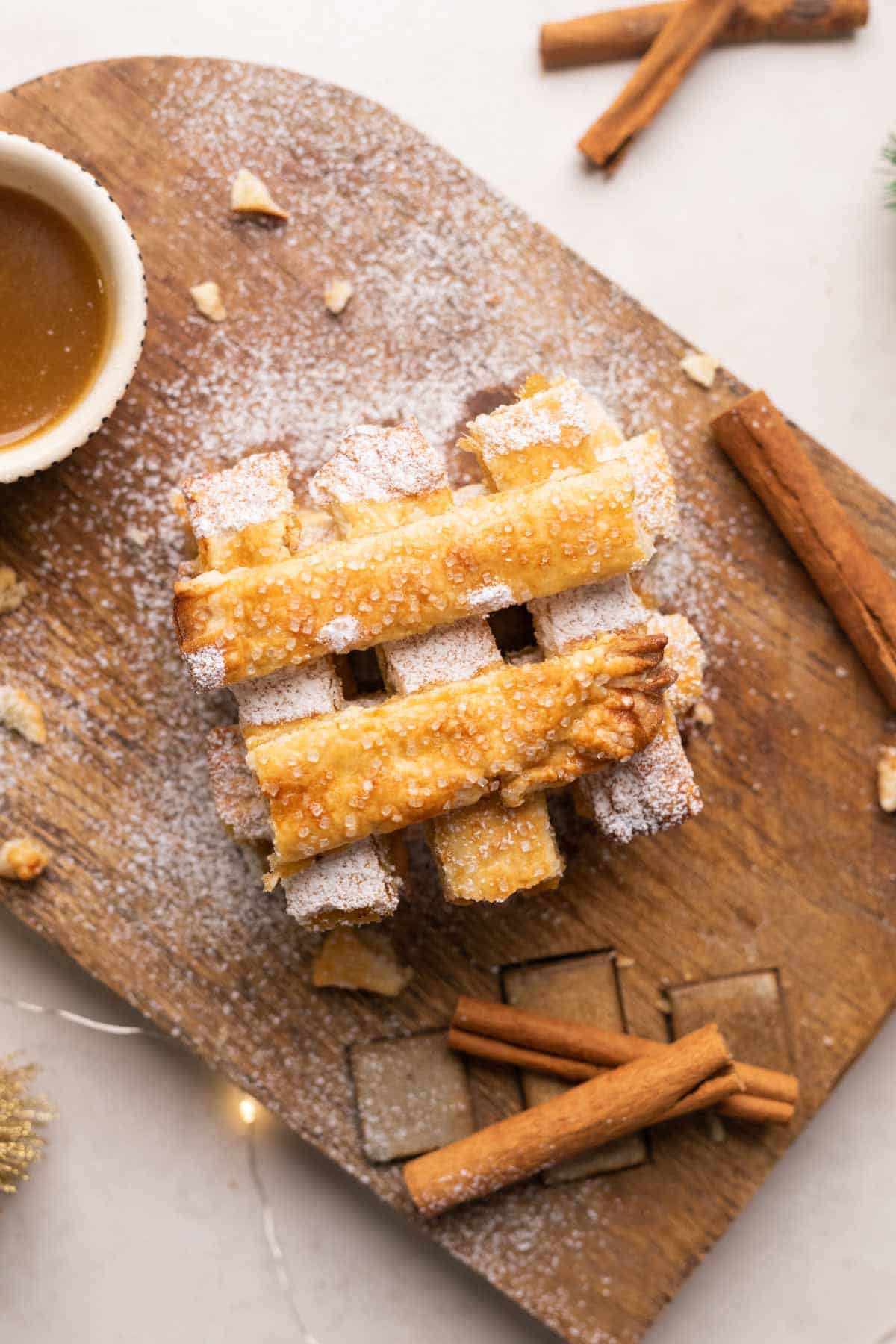 Apple Pie Fries stacked on a wooden workbench with salted caramel sauce.