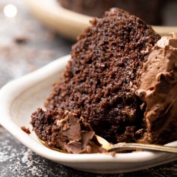 picture of a slice of chocolate cake topped with chocolate buttercream with a spoon