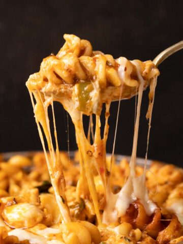 Closeup of air fryer baked pasta in red sauce being eaten with a fork