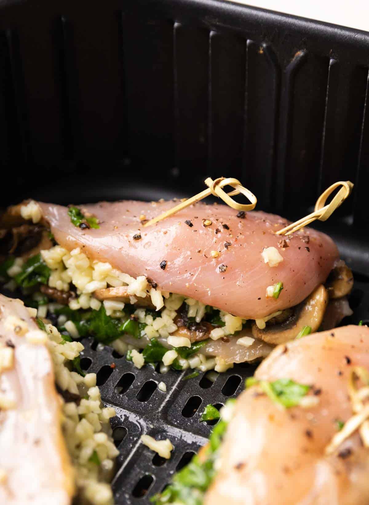 stuffed chicken breasts placed in an air fryer