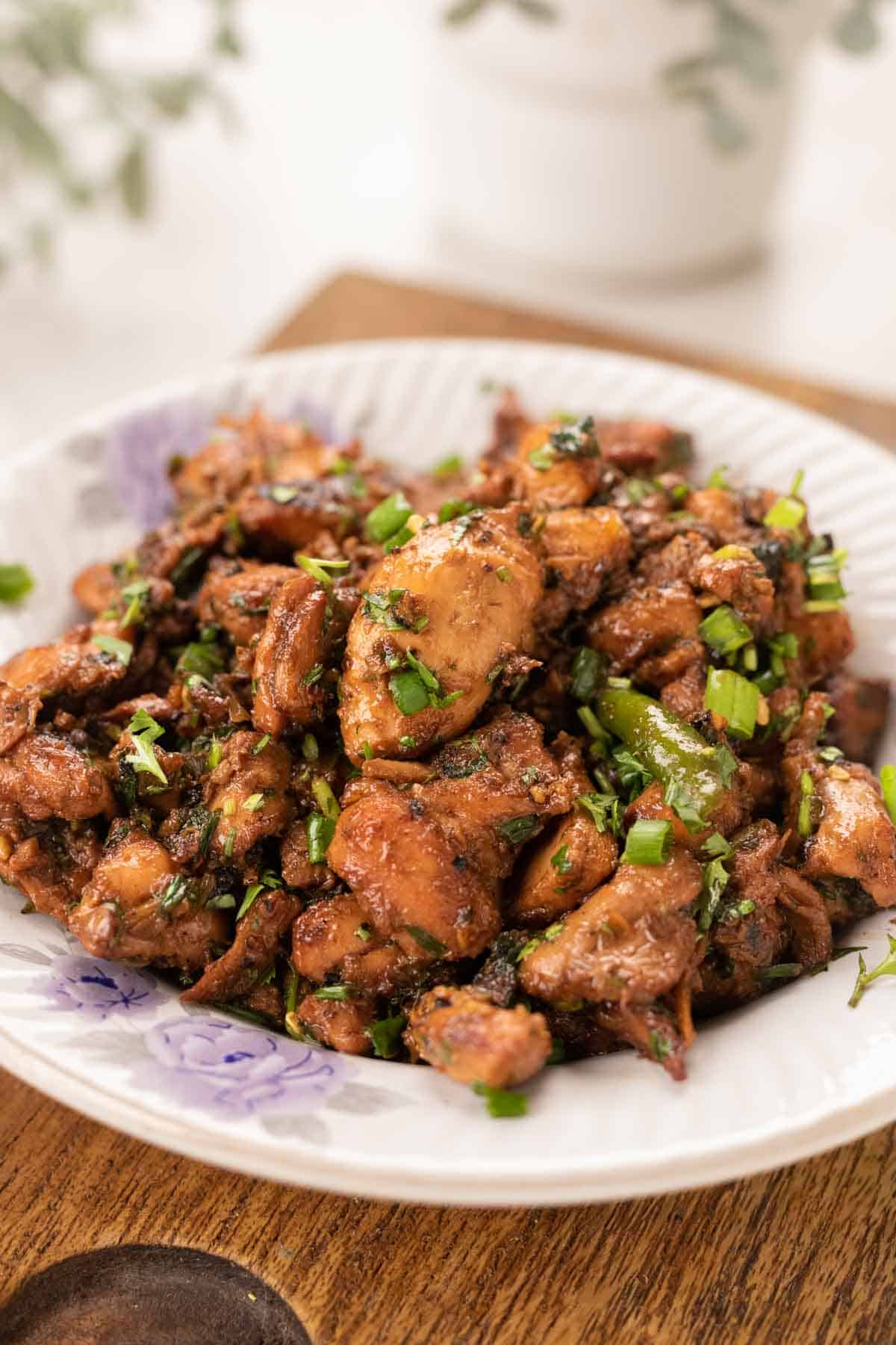 plate with ginger chicken topped with spring onions