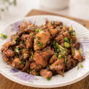 plate with ginger chicken topped with spring onions