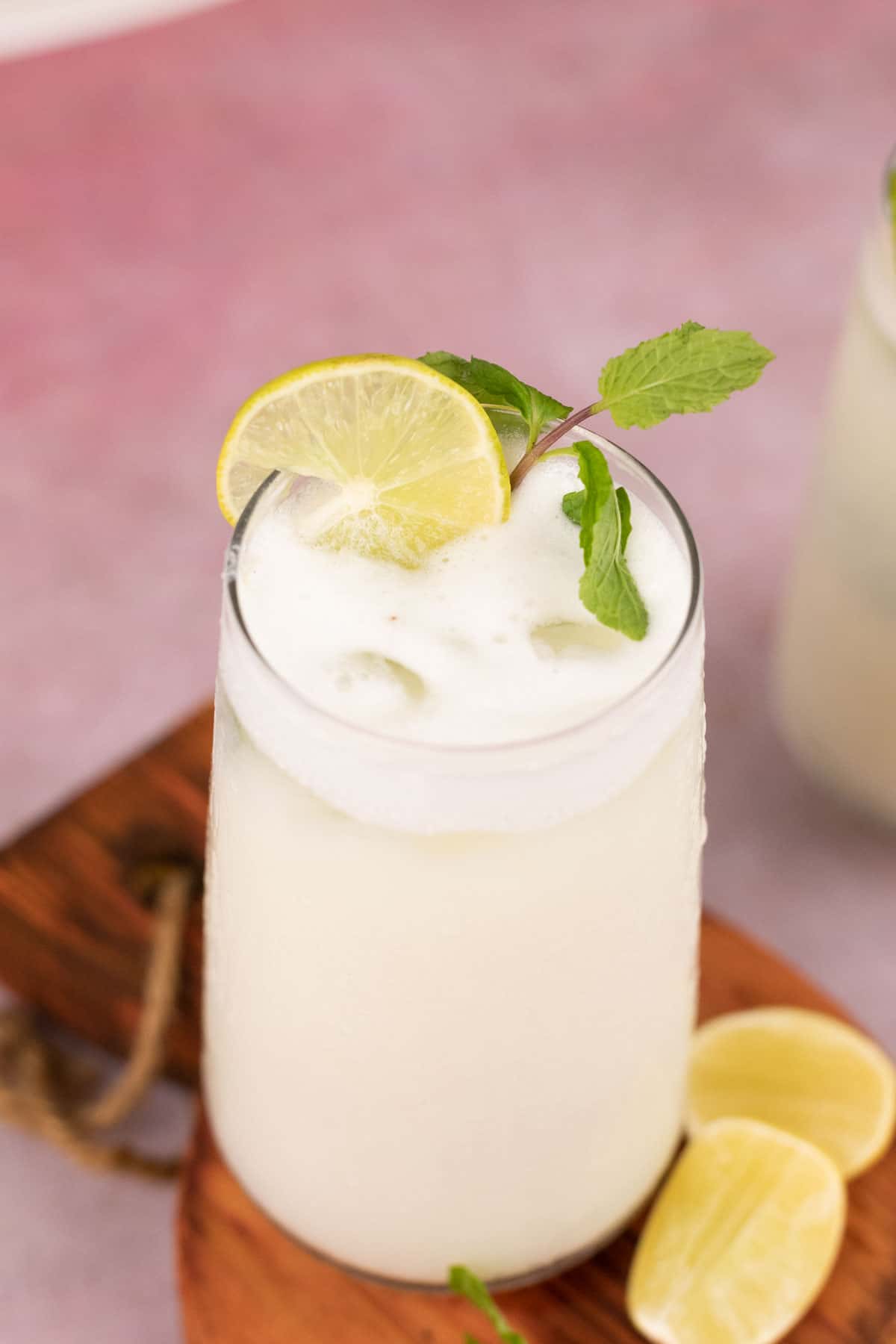 glass with limonada  with a sprig of mint and slices of lemon on the side
