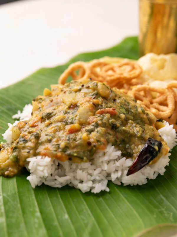 rice served on banana leaf with andhra pappu, with fryums and chutney podi