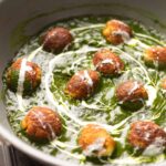 The Healthy Palak Paneer Kofta Curry in a pan with cream drizzled on top