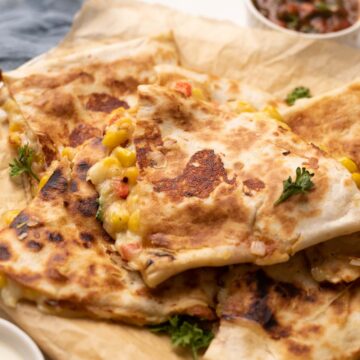 bell pepper corn and cheese quesadilla with crispy bits of cheese with a side of tomato salsa
