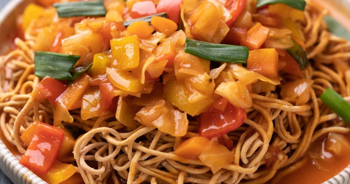 Sweet and Sour Vegetables served on crispy fried noodles in a white plate