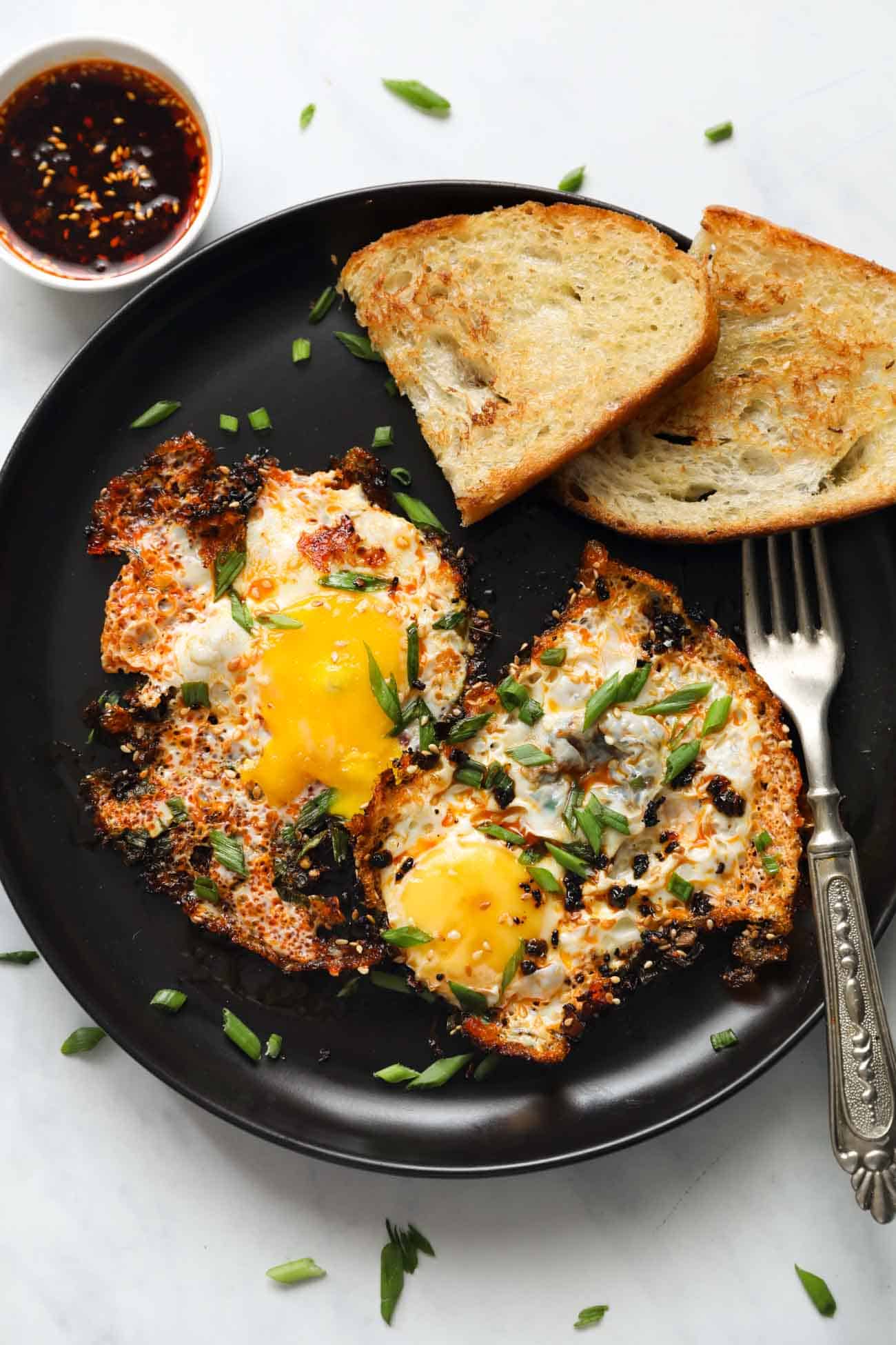 plate of fried eggs with chilli oil and a side of toast