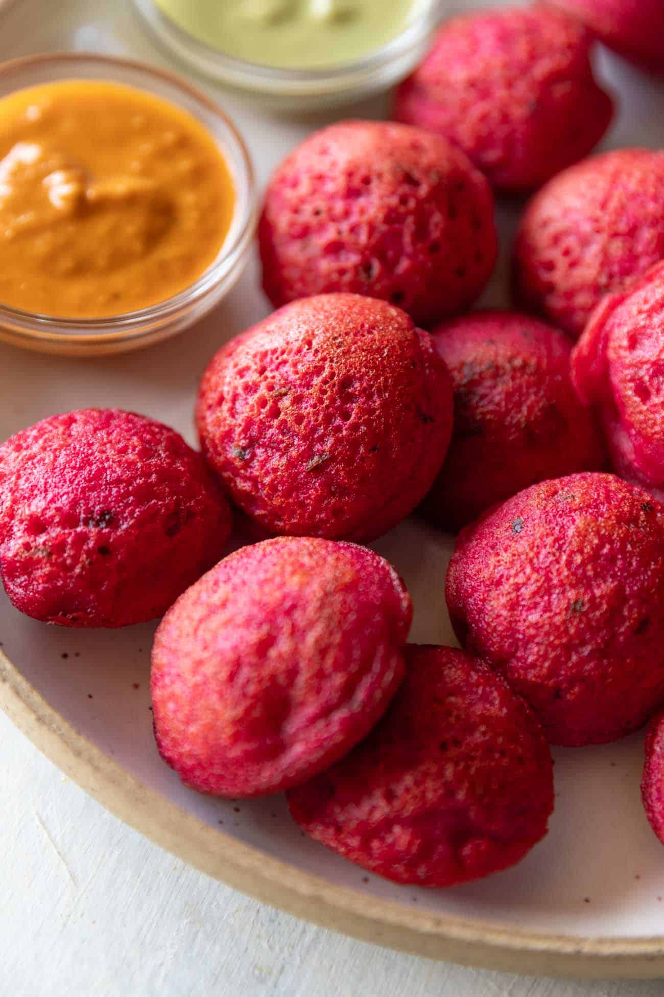 Beetroot appe served on a plate with chutney on the side