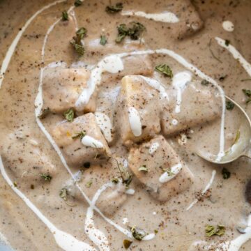 paneer kali mirch gravy served in a bowl with cream drizzled on top