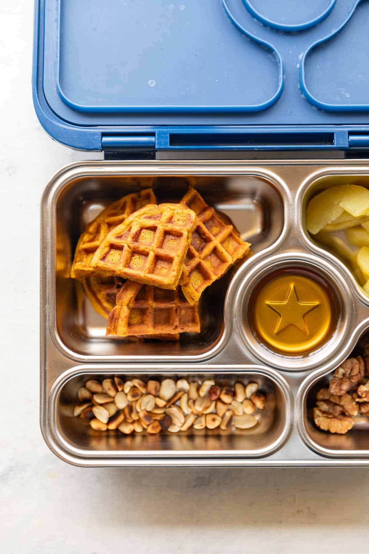 Pumpkin waffles in a kids lunch box along with other foods