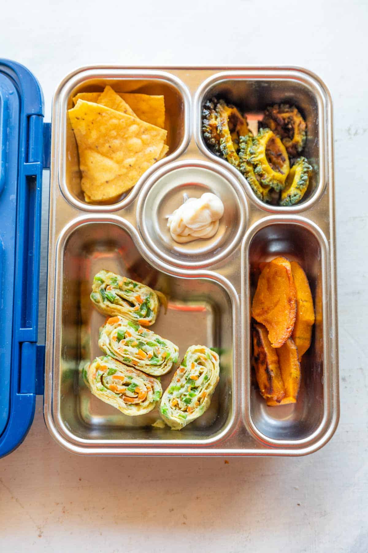 a picture of a tiffin box with different items including a korean omelette roll