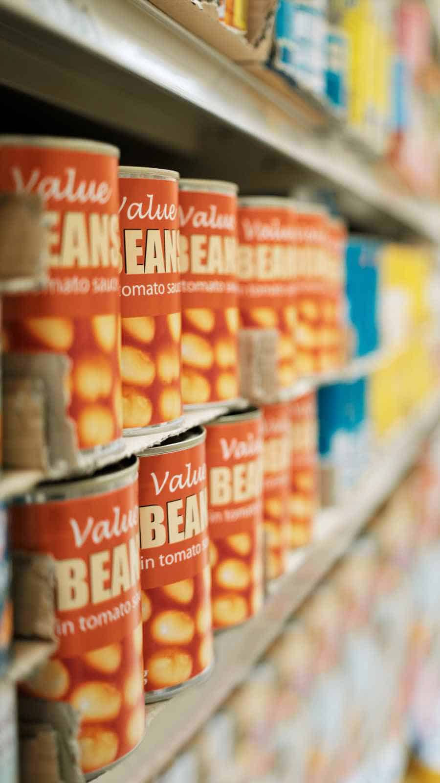 An image showing groceeries in a supermarket with a focus on canned beans