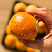 a person holding an air fryer dinner roll to showcase it's golden exterior
