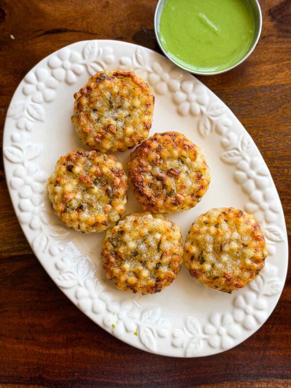 Crispy crunchy golden brown sabudana vadas served on a white platter with green mint chutney